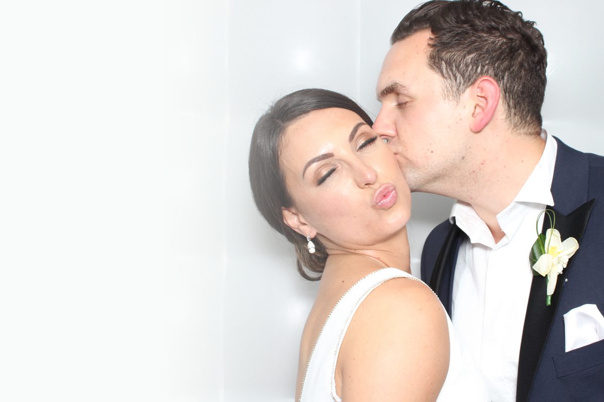 Bride and groom enjoying a luxury wedding photo booth experience