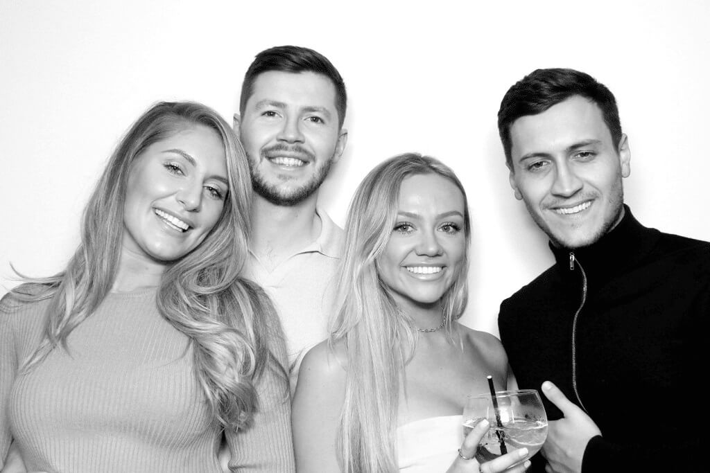 Four guests posing together for a black and white Hollywood Glam photo booth photo